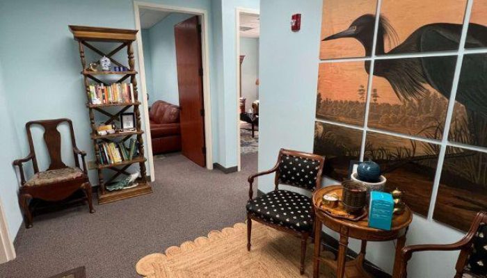 This is an image of a therapist office in Stuart, Florida with wooden furniture and blue heron Audubon painting.
